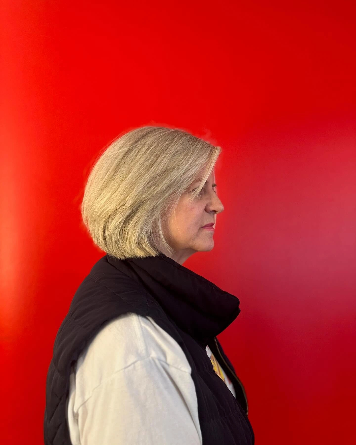 Client with a graduated blonde bob against a red background